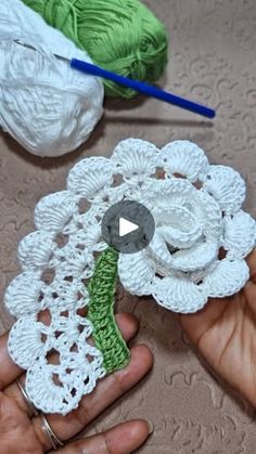 crocheted flower being held by someone's hand