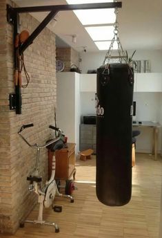 a gym with a punching bag hanging from the ceiling and a bike parked next to it