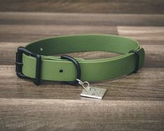 a green leather dog collar with a metal tag on the front and back of it