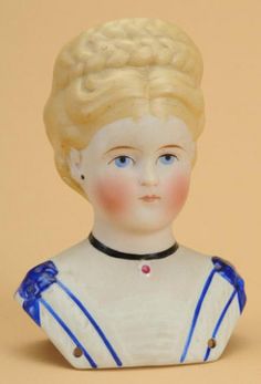 an old porcelain doll with blonde hair and blue dress