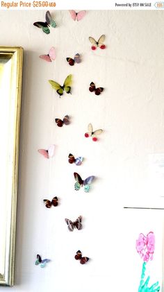 the butterflies are hanging on the wall next to the mirror