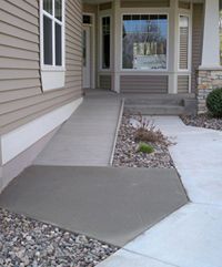 the front entrance to a house with gravel on the ground