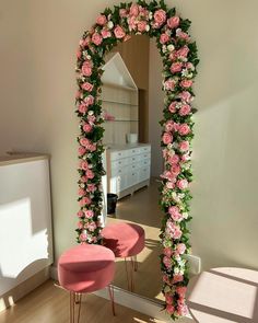 a mirror that has flowers on it and some stools in front of the mirror