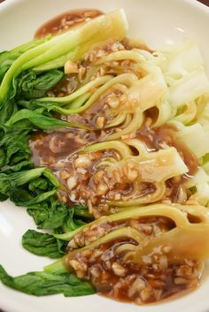 some food is on a white plate with broccoli florets and sauce