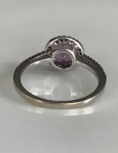 "This lovely halo ring features one round amethyst surrounded by tiny round diamonds that extend to about 1/4\" along the band on either side. The delicate purple shine of the amethyst and the twinkle of the diamonds make this ring simply dreamy! It is marked 14K, is a size 6 1/2 and is in beautiful condition. Please see all photos for details. Thank you for looking! I'm happy to offer layaway on certain items. Please ask for details." Purple Diamond Ring With Halo Setting And Round Cut, Purple Round Cut Rings With Halo Setting, Classic Purple Round Band Ring, Purple Round Cut Halo Setting Rings, Classic Purple Diamond Ring With Halo Setting, Fine Jewelry Amethyst Halo Promise Ring, Purple Diamond Ring With Halo Setting, Fine Jewelry Amethyst Ring With Halo For Promise, Purple Diamond Halo Ring