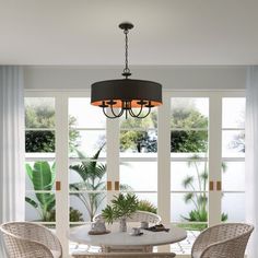 a dining room table with chairs and a chandelier hanging from it's ceiling