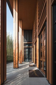 an empty walkway between two buildings with wooden slats on the sides and doors to another building