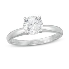 a white gold engagement ring with a round cut diamond in the center, on a plain band