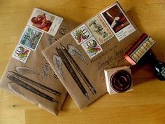 two envelopes with stamps on them are sitting next to a rubber stamp and some other items