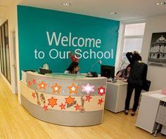 people are standing in front of a welcome to our school sign with stars on it