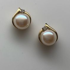 Set Securely At The Bottom Of These Earrings Is A Beautiful 7 Mm Pearl. The Pearls Are Slightly Button Shape And Have A Cream White Color With No Major Flaws Or Visible Blemishes. There Is A Wave Of Gold With A Decorative Cut Out Above The Pearl Along With One Small Diamond. These Earrings Measure 10 1/2 Mm From Top To Bottom And 9 Mm From Side To Side. They Have Stud Posts And Come With Friction Push Backings. Both The Backings And The Settings Are Solid Yellow Gold, And Are Stamped 10k Brand N Cream White Color, June Birthstone, Diamond Stud Earrings, Diamond Stud, The Pearl, June Birth Stone, Solid Yellow, Diamond Earrings Studs, Cream White