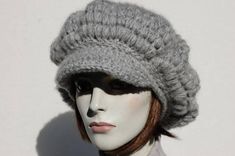 a mannequin head wearing a gray knitted hat