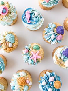 cupcakes decorated in pastel colors with sea shells and seashells