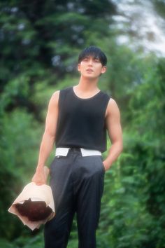 a young man is holding a paper bag