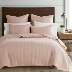 a bed with pink bedspread and pillows