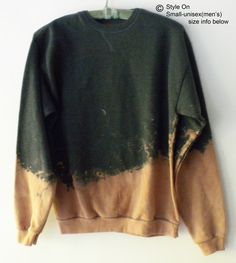 a green and brown sweatshirt hanging on a white wall