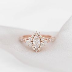 a close up view of a diamond ring on top of a white cloth with the background