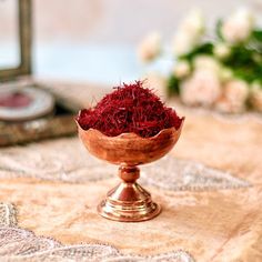 a wooden bowl filled with red flowers on top of a table