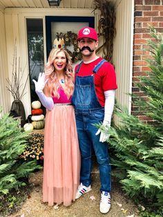 a man and woman dressed up as mario and princess peach are standing in front of a house