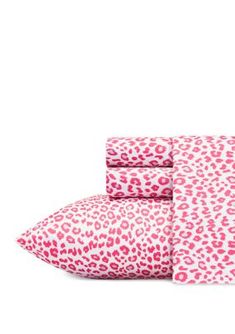 the pink and white leopard print sheets are folded on top of each other with matching pillows