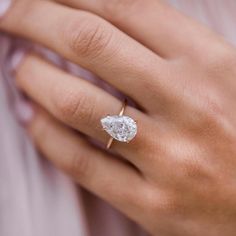 a woman's hand with a diamond ring on it