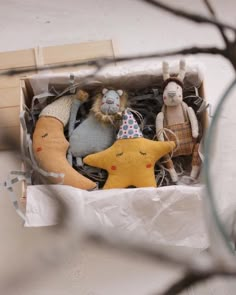 several stuffed animals in a box on a table