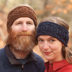 a man with a beard standing next to a woman wearing a knitted headband