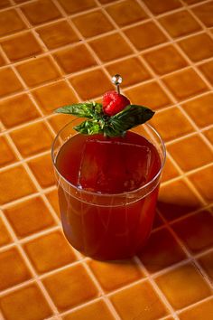 a red drink in a glass on a tiled floor