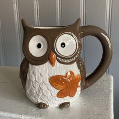 a ceramic owl mug sitting on top of a table