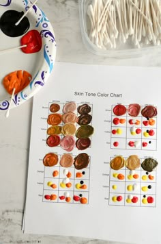 the color chart for skin tone is displayed next to some paint and toothpicks