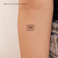 a small tattoo on the arm of a person with a tape recorder in front of them