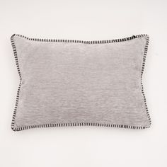 a gray pillow with black piping on the front and back, against a white background