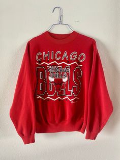 "Vintage 1990's Chicago Bulls Heavyweight Sweatshirt Pullover style, bright red, super cozy. In mint condition, possibly never worn. Graphic super vibrant, no stains or holes.  Officially Licensed product of the NBA - Team Hanes production. Tag size Men's XL maybe more like a modern day Large. See measurements to be sure of fit.  Measurements lying flat: pit to pit: 24\" shoulders: 22.5\" sleeve: 22.5\", length: 25\"" Red Graphic Sweatshirt For Sports Events, Red Sweatshirt For Sports Season Fan Merchandise, Red Sweatshirt For Sports Fan Merchandise, Red Graphic Print Sweatshirt For Sports Events, Throwback Red Tops For Sports Events, University Red Sweatshirt For Streetwear, University Red Sweatshirt For Sports Season Streetwear, University Red Sweatshirt For Sports Season, Red Sweatshirt For Streetwear, Fan Apparel