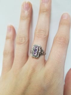 Once in a Blue Moon beautiful vintage finds. Amethyst Filigree Ring // Solid 925 Sterling Silver. Antique Remake. There are three 0.08 ct stones in a beautiful filigree setting. Beautiful anniversary present, Mother's Ring, or Birthday gift. Size: 6, 7, 8 US* Total Carat Wt: 0.24 ct Band width: 1.6 mm *Ring sizes may be 1/4 smaller than size selected Free Shipping & packaged in a black velvet ring box ready to gift! Vintage Purple Round Jewelry, Vintage Purple Sapphire Gemstone Ring, Vintage Purple Amethyst Ring For Anniversary, Vintage Purple Hallmarked Jewelry, Antique Rings With Accent Stones For Gift, Vintage White Gold Promise Ring Jewelry, Collectible Silver Jewelry With Accent Stones, Vintage Amethyst Jewelry For Gifts, Vintage Silver Diamond Ring With Gemstone