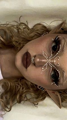 a woman with makeup and pearls on her face