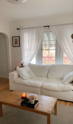 a living room with a white couch and coffee table in front of a large window