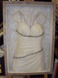 a wedding dress in a box on display