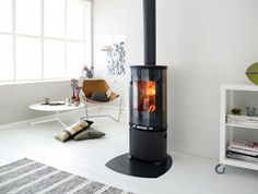 a black stove sitting in the middle of a living room next to a white wall