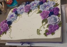 a white cake with purple and blue flowers on it