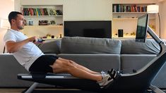 a man sitting on top of a chair with a remote control in his hand while holding a game controller