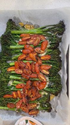 some broccoli and carrots are arranged on a tray with sauce in it