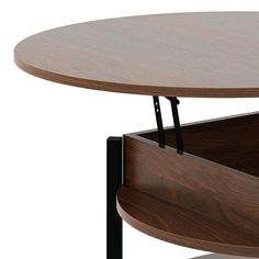 a wooden table with two black metal legs and a round wood table top that has an open shelf underneath it