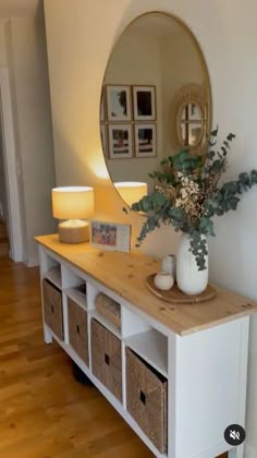 a white table with baskets under a mirror