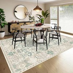 a dining room table with chairs and a rug in front of the window is shown