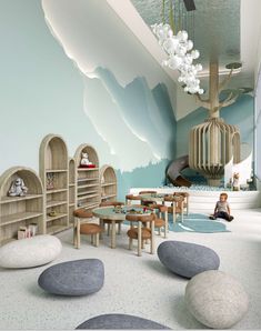 a child's playroom with rocks and toys on the floor in front of a mountain mural