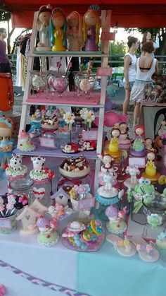 there are many different cakes and cupcakes on display at this outdoor market stall