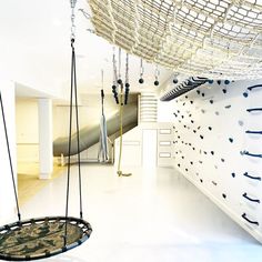 an indoor climbing wall and swing set in a room