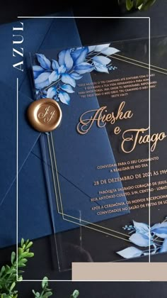 an elegant wedding card with blue flowers and gold foil on the inside is displayed next to greenery