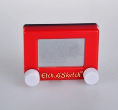 an old fashioned red toy radio with white knobs on the front and bottom sides