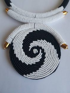 "This necklace is 100% handcrafted using white and black beads. Measurements: 18 inches around the neck. Pendant: 4\" Perfect for weddings, African themed events, traditional events etc. **Buy multiple items and pay shipping for 1 item only.The rest ships free. More neckleces here; https://www.etsy.com/shop/TribalTess?ref=seller-platform-mcnav&section_id=21306083 Back to my shop; https://www.etsy.com/shop/TribalTess?ref=seller-platform-mcnav" White Beaded Necklaces With Black Beads As Gift, White Beaded Necklaces With Black Beads For Gifts, White Beaded Necklaces With Large Beads, White Beaded Necklace With Large Beads, White Beaded Necklace With Large Round Beads, White Necklaces With Black Beads, Handmade White Beaded Round Necklace, Unique White Jewelry With Black Beads, Neck Pendant